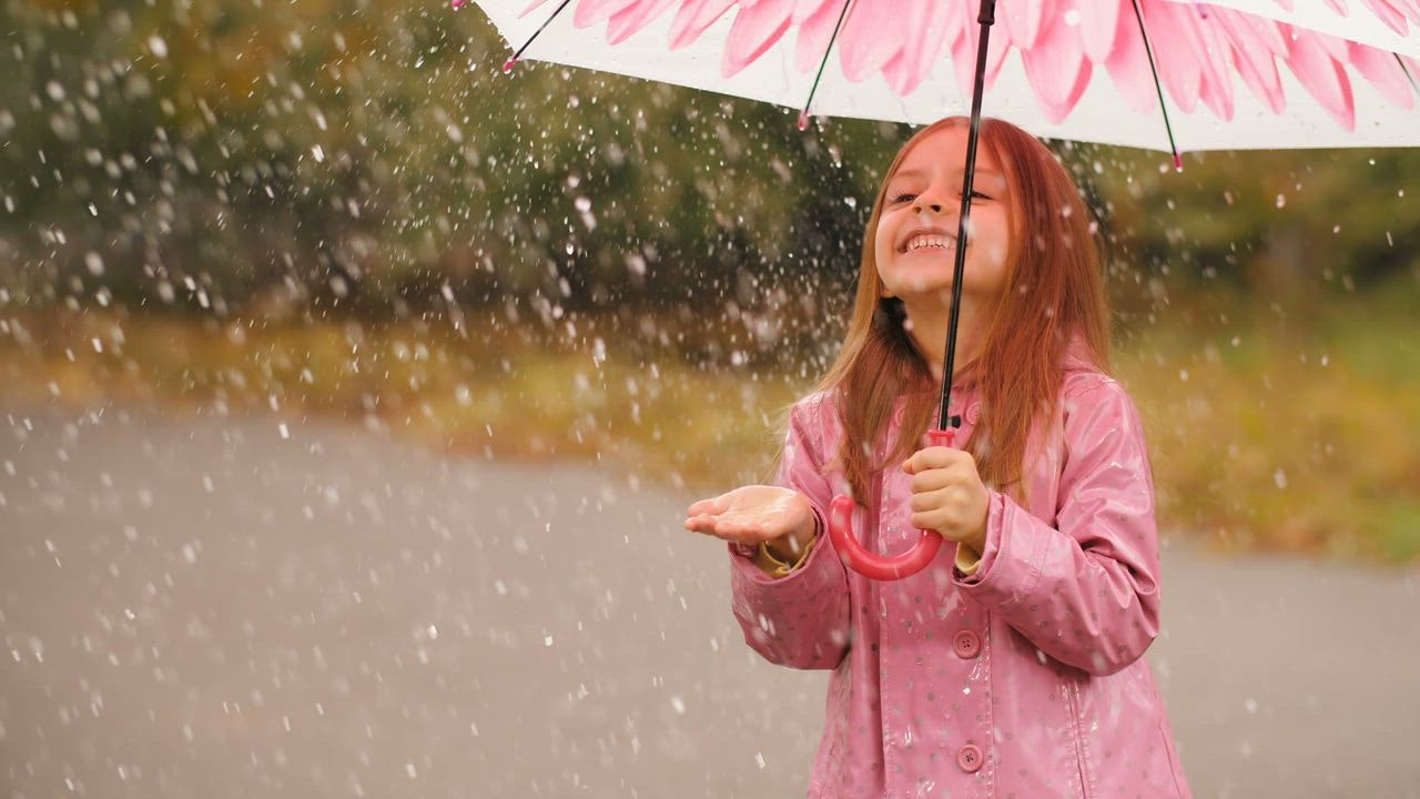 mixkit-happy-girl-with-an-umbrella-in-the-rain-33520-0